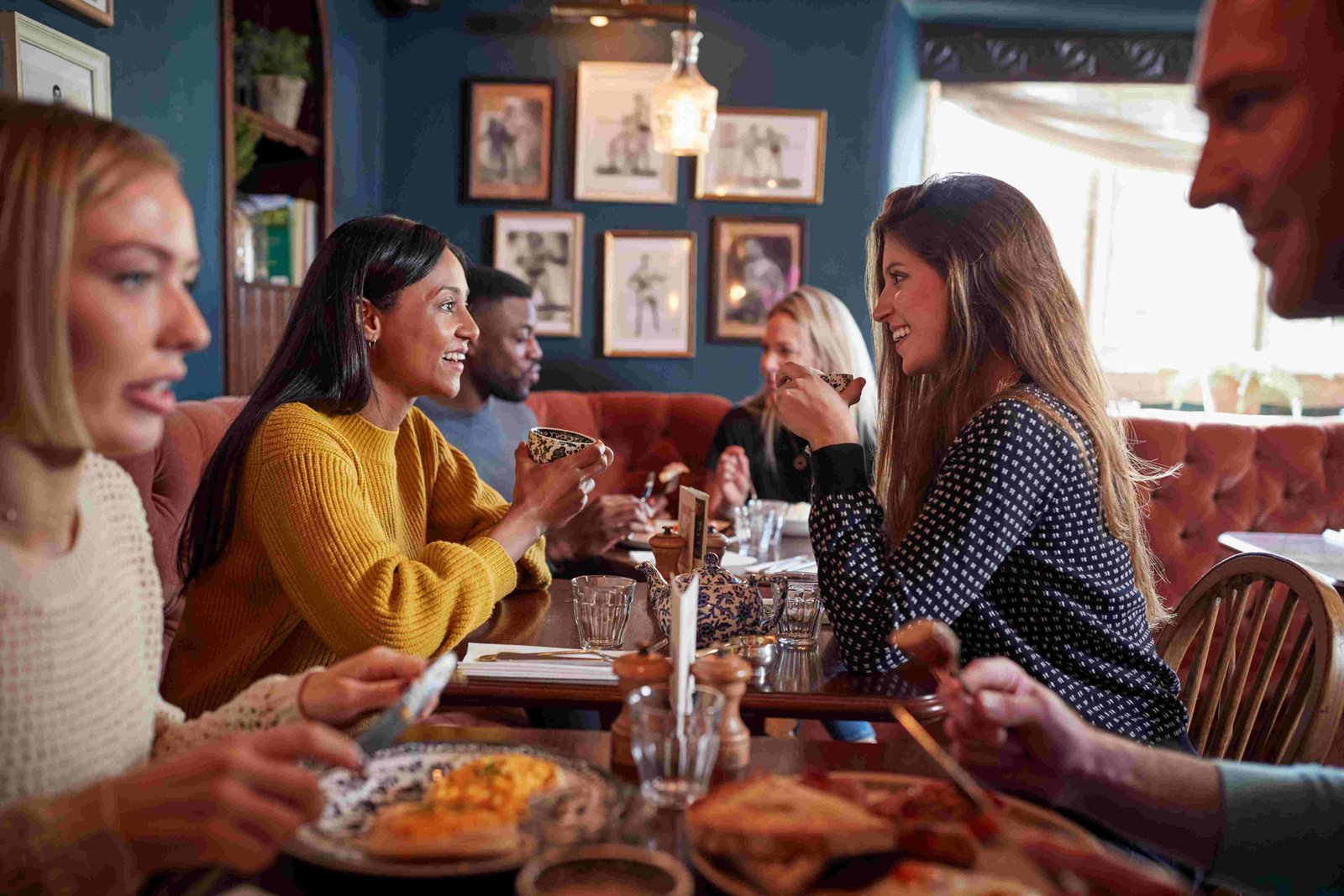 Diners eating and talking at a table in a busy restaurant