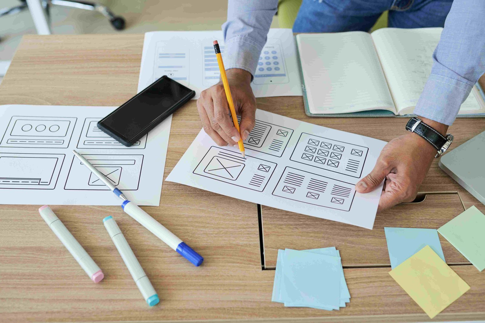 A designer planning a website layout at a desk